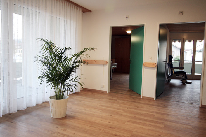 Helle Räumlichkeiten im Pflegeheim. Zugang Einbettzimmer mit Balkon und Therapieraum